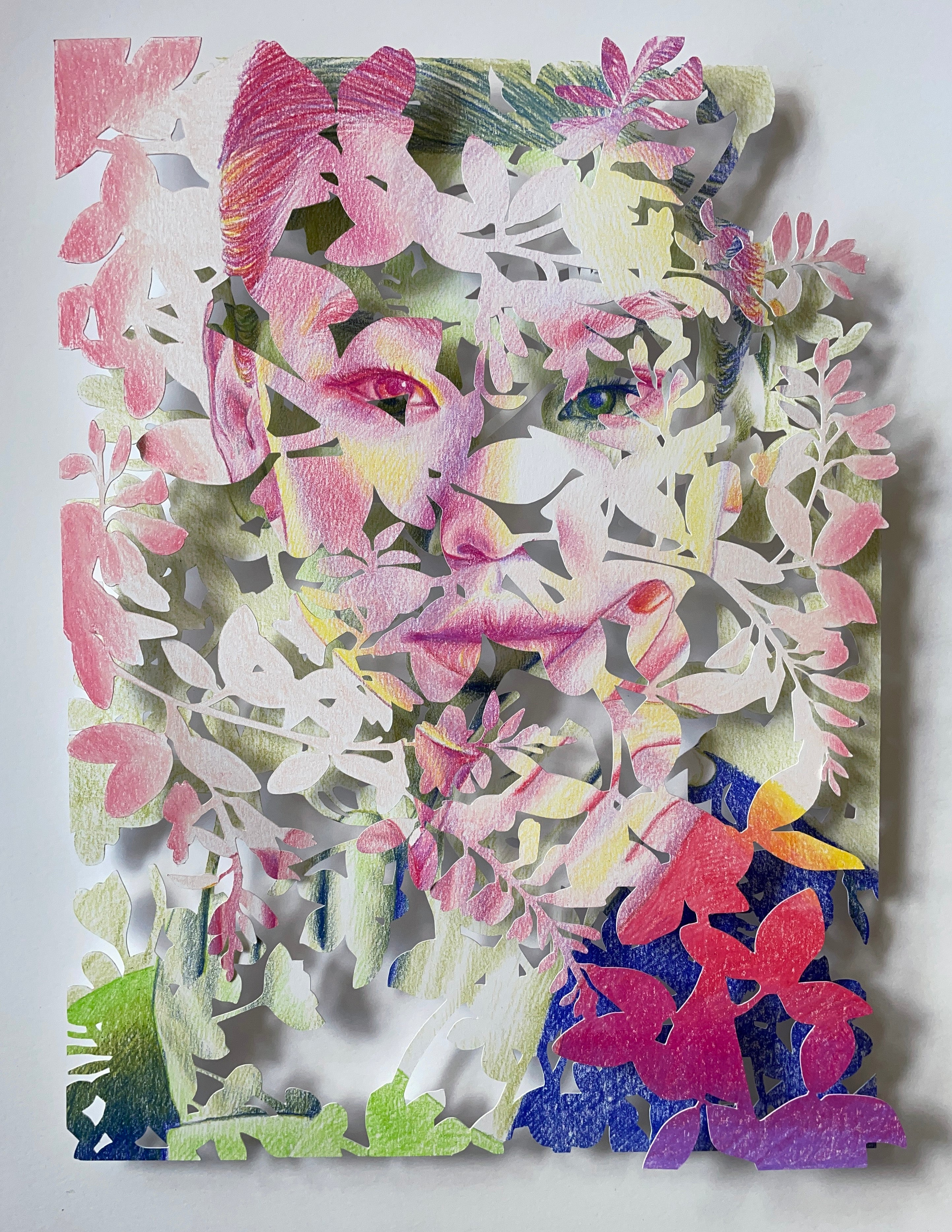 Under the Wisteria Tree by Christine Kim – Artistic depiction of a face made from colorful paper cutouts of flowers and leaves on a white background.